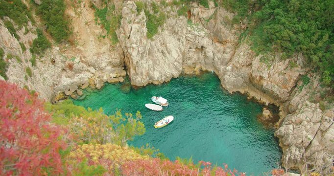 Boats anchored in a sheltered rocky cove during a summer coastal trip in Capri
