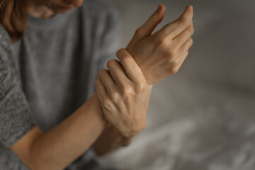 Woman suffering from his wrist joint pain at home
