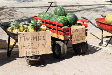 Fresh watermelons and pineapples at a rustic market stand, watermelons concept