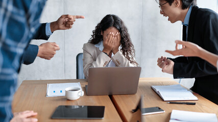 Workplace Conflict And Bullying. Aggressive Coworkers Yelling At Victimized Businesswoman Sitting...
