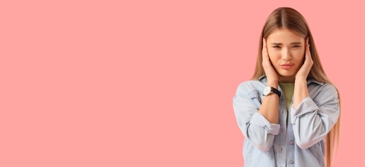 Young woman suffering from loud noise on pink background with space for text