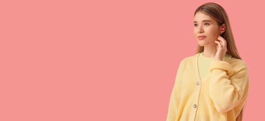 Young woman with earplugs on pink background with space for text
