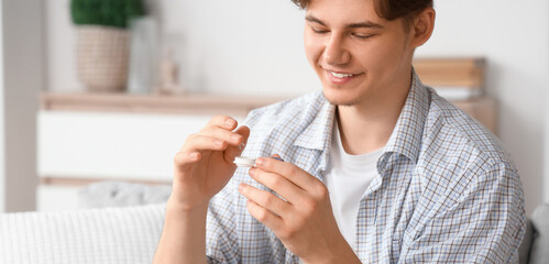 Young man with contact lenses sitting on sofa at home
