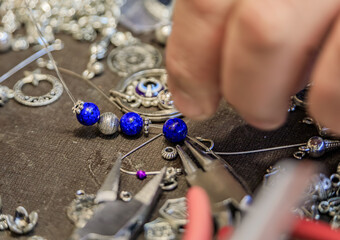 Jeweler s workspace with lapis lazuli and silver beads, tools, for a custom made unique bracelet at the Grand Bazaar in Istanbul, Turkey