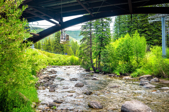 Gore creek river water near Lionshead by Vail Colorado village ski resort town park in summer with ski lift gondola above bridge - Powered by Adobe