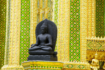 Serene Buddha Statue Against Vibrant Traditional Architecture