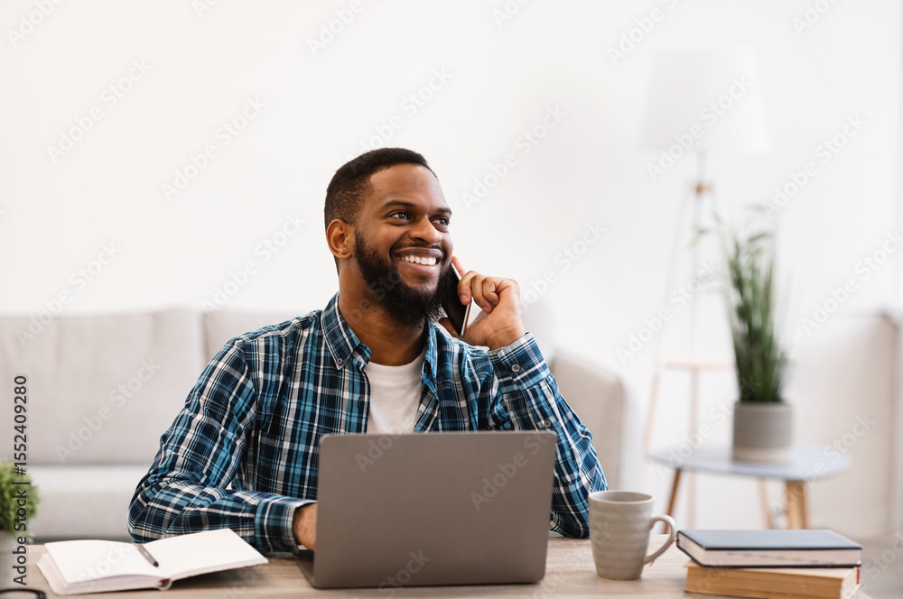 Aufkleber smiling black businessman talking on phone sitting at workplace in modern office. mobile business co