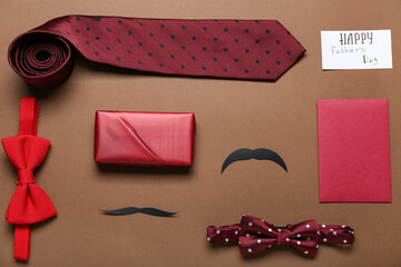 Paper with text HAPPY FATHER'S DAY, mustaches, accessories, gift and envelope on brown background