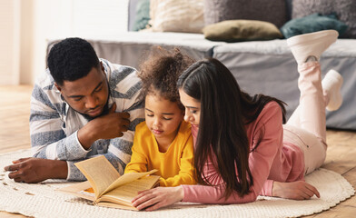 Reading lessons in an international family on the floor at home during covid-19 quarantine