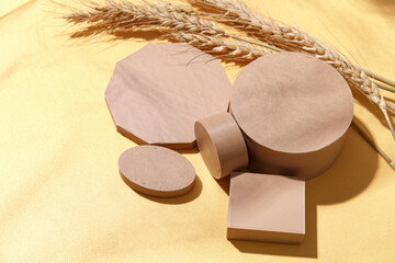 Decorative plaster podiums and wheat ears on orange background