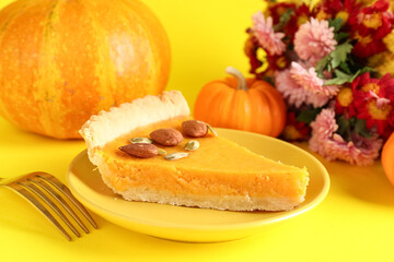 Plate with piece of delicious pumpkin tart and beautiful flowers on yellow background