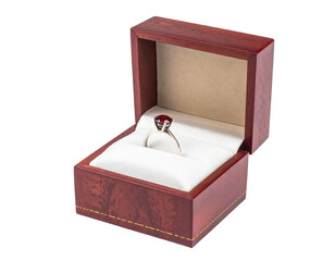 A ruby ring rests in a dark wood jewelry box