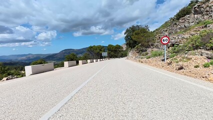 A picturesque mountain road surrounded by lush greenery and vibrant skies, perfect for travel footage.