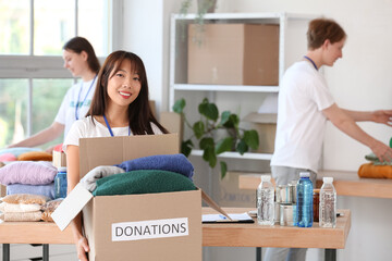 Young female volunteer with donations for poor people in center