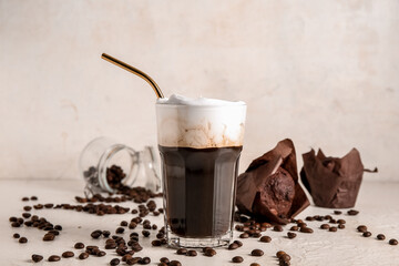 Glass of hot coffee with whipped cream and sweet chocolate muffins on white background