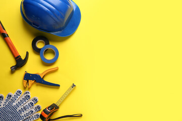 Hardhat and construction tools on yellow background