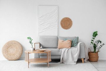 Sofa and wooden coffee table near white wall in interior of living room