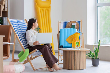 Young businesswoman working in office before vacation