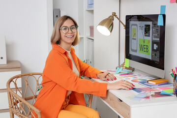 Female web designer working with computer at table in office