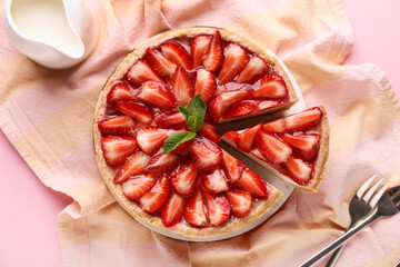 Cut sweet strawberry tart with mint and jug of fresh milk on pink background