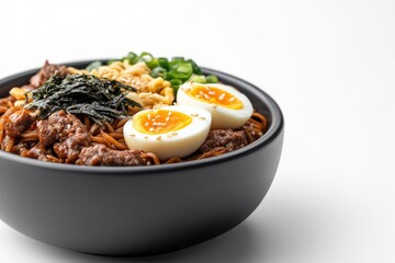 Side angle shot of a rich, flavorful bowl of Korean noodles topped with boiled egg halves, seaweed strips