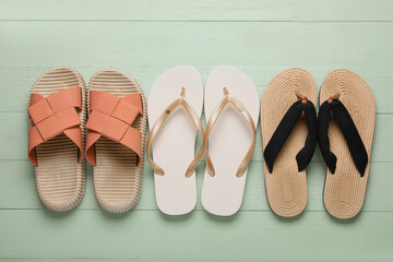 Composition with different stylish flip-flops on green wooden background