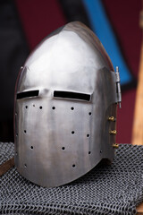 medieval helmet, likely a type of great helm or a bascinet, known for its protective qualities. It...