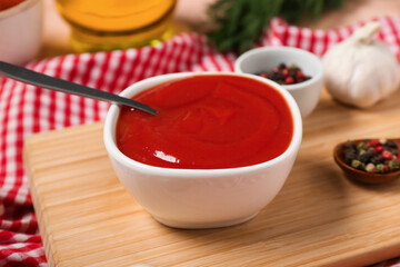 Bowl of tasty ketchup and peppercorns on table, closeup