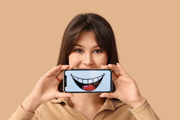 Young woman holding mobile phone with smile on beige background, closeup
