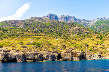 Ikaria island, Greece landscape of Greek mountains cliffs and blue sky near Magganitis Seychelles Beach at Icarian Mediterranean sea