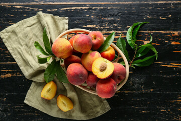 Basket of fresh peaches on dark wooden background, top view