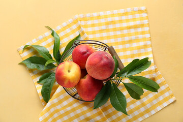 Basket of fresh peaches on yellow background, top view