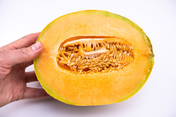 Cantaloupe muskmelon sol glow melon one vibrant colorful yellow half cut, hand holding fruit and macro texture of seeds on white background