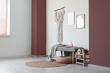 Comfortable grey bench, pouf and shelving unit near white wall in interior of hall