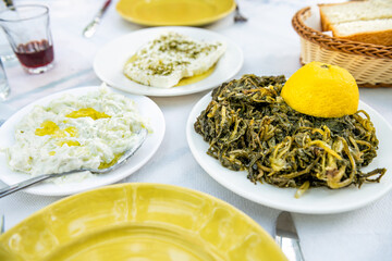 Horta wild greens, tzatziki olive oil, feta kathoura Ikarian cheese food at restaurant on Ikaria island, Greece longevity blue zone diet