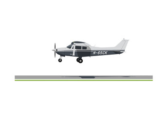 Gray and white single engine airplane sitting on a runway with green grass on either side