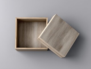 A light-grey background showcases a partially open square wooden box, revealing its empty, light-brown interior. The wood grain is visible on both the lid and base