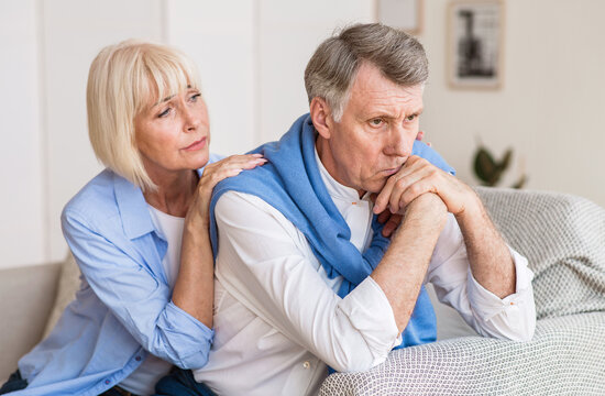 Problems in relationships. Senior woman consoling husband after arguing at home - Powered by Adobe