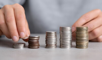 Hands adding coins to stacks of coins, rising columns made from the coins, Generative AI