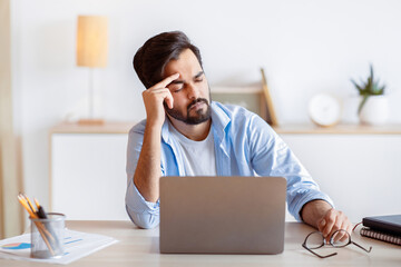 Overworked Arab Businessman Suffering From Migraine At Work, Having Strong Headache. Stressed...