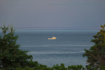 Sailing boat in the sea at sunset, prince edward island Canada. High quality photo