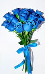 Fresh beautiful bouquet of blue roses. Flowers tied with a blue bow, ribbon, on a white background. Object isolated.