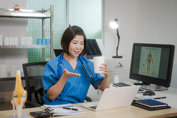 A middle-aged Asian female doctor at her desk,explaining various bone and joint diseases like...
