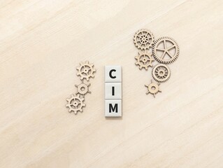 Cogwheels and square mosaic with letters SIM stand for Computer Integrated Manufacturing. technology