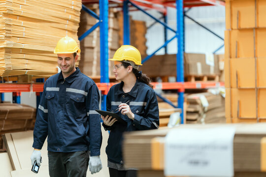 Young employee checking stock In a large cardboard factory