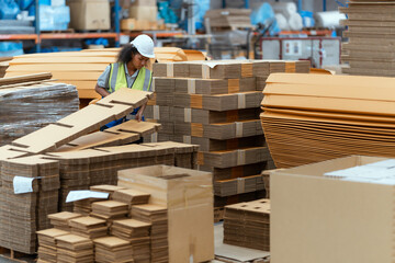 Machine operators work in a large paper factory and check stock of cardboard boxes. © 2B