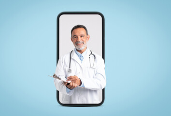 Happy confident european old doctor in white coat with stethoscope makes notes on big phone screen...