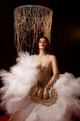 Young Caucasian circus performer or burlesque dancer in golden vintage corset, front view, posing...