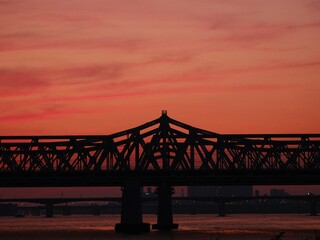 Naklejka premium Silhouette of a steel bridge at sunset over Han River