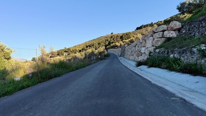 Capture of a stunningly picturesque, winding road that is beautifully surrounded by lush green...